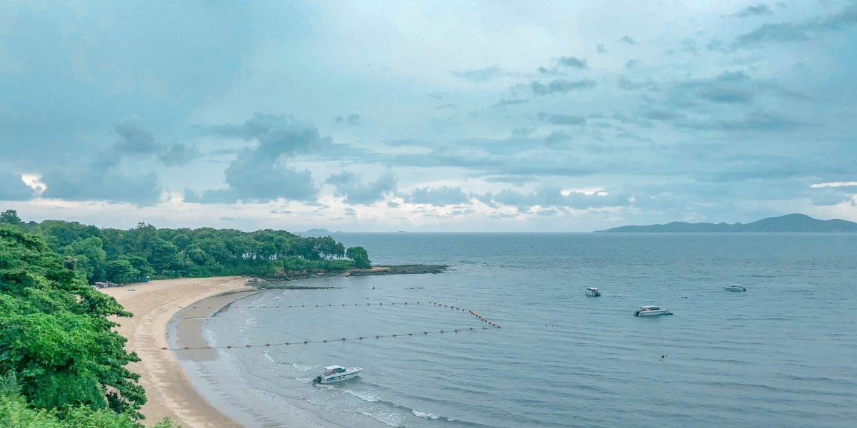 beautiful-shot-beach-shore-with-boats-water-blue-cloudy-sky