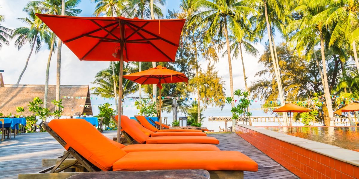 Umbrella and chair around swimming pool in hotel and resort - Holiday Vacation concept