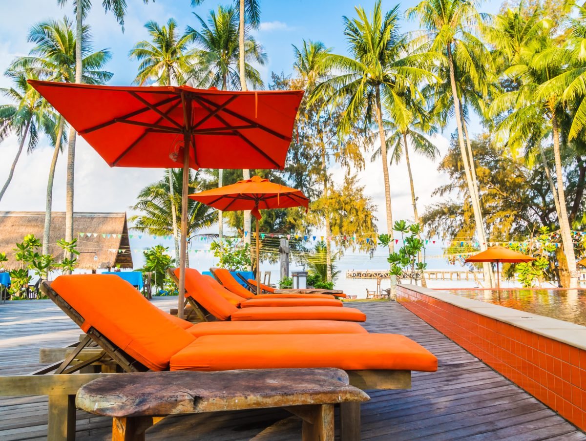 Umbrella and chair around swimming pool in hotel and resort - Holiday Vacation concept